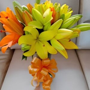 Jarrón de vidrio con lirios amarillos y naranjas frescos en Bosa R143 - Floristería en Bosa Te Mando Flores.